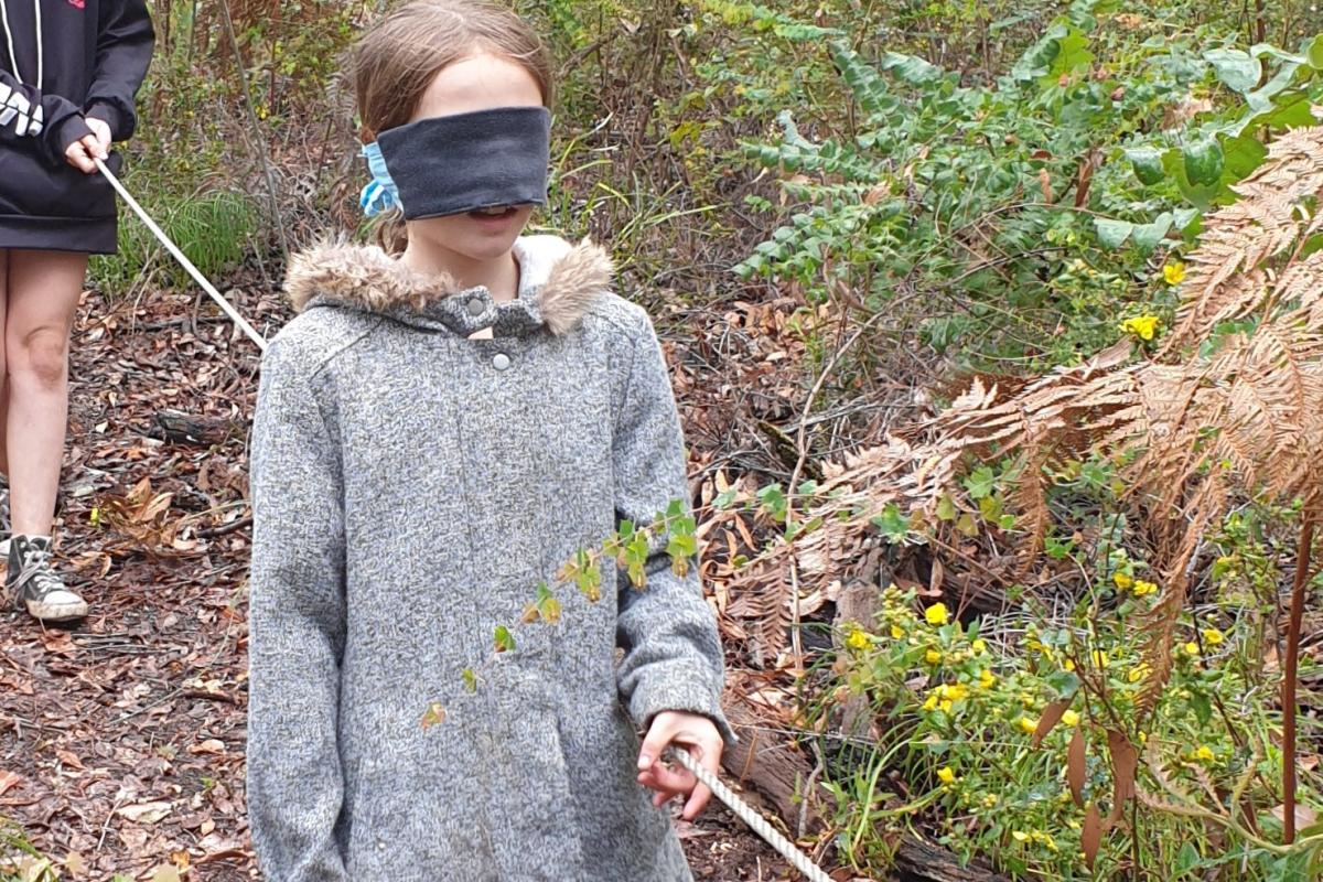 Senses activity - girls walking through bush blindfolded.